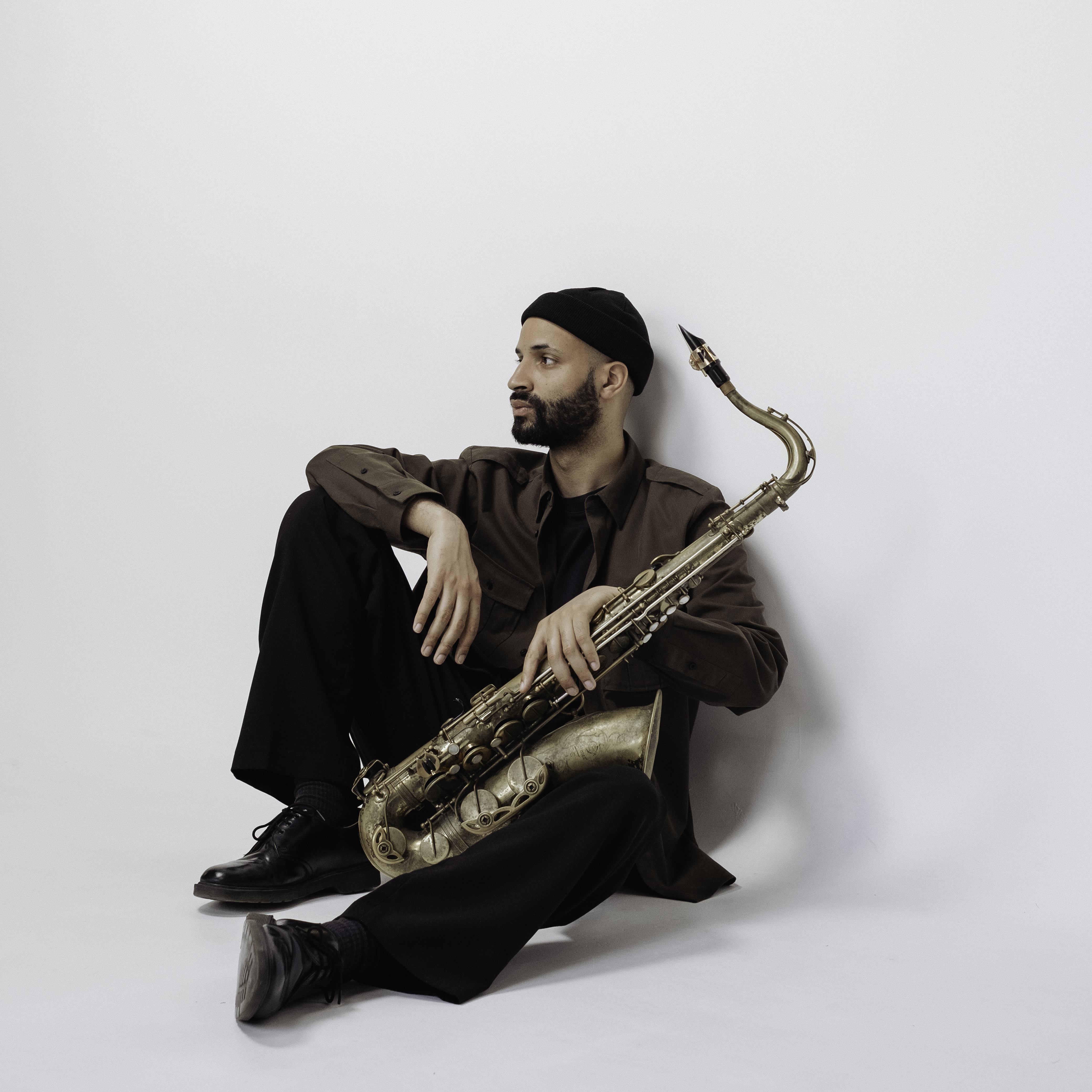 Musina Ebobissé assis avec son saxophone